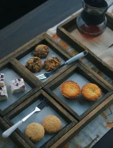 Selection of bite-size pastries and cookies beside multiple cups of brewed coffee on a wooden serving tray at Seeker Yunnan Coffee Estate