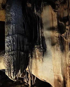 Limestone cave chamber on a Lyra Cruise Collection 4D3N luxury Halong Bay cruise, with stalactites and an illuminated passage