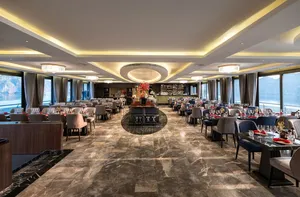 Doris Cruise 5-star dining room with set tables and panoramic windows overlooking views from the ship in Halong Bay