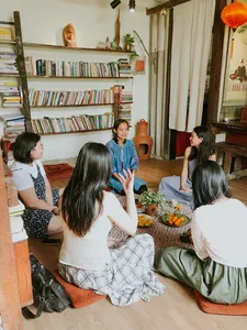 Sekelompok orang duduk melingkar mendengarkan tuan rumah berbagi budaya di Chan Dat Living Room, homestay nyaman di Hoi An