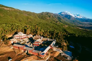 Aerial view of The Bivou Lijiang, a courtyard boutique stay near Lijiang with snow-capped mountains in the distance