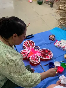 Ho Chi Minh City artisan painting red and pink lantern crafts on a blue tablecloth in a craft workshop, Viet Awesome Tours