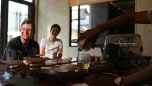 Detik merasa teh ketika pemandu tempatan menuangkan teh untuk kumpulan kecil di meja dalam pengalaman teh 3H2M di Xishuangbanna