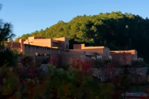 Retret eco Shaxi oleh Linden Centre di Dali, halaman batu bermandikan cahaya matahari di lereng bukit dengan semak dan bunga-bungaan di sekelilingnya
