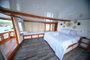 Double bed suite with sea-view windows on a boat for a 3D2N join-in Komodo trip from Labuan Bajo to Komodo Island