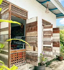 Ilham Ceramic studio exterior in Langkawi village with open wooden shutters, shaded shelves and potted flowers