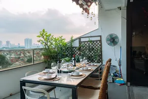 Cosy loft balcony dining table with glasses and wine, overlooking Singapore skyline—ideal for private dining Singapore