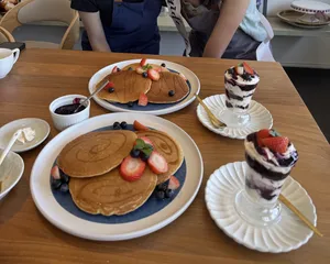Pancake terinspirasi TCM dengan topping beri dan daun mint, serta dessert cup berlapis di atas piring putih saat lokakarya Food as Medicine di Singapura