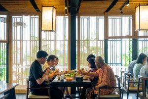 Group seated at a dining table with Vietnamese dishes in a bright Hanoi room during an Up Travel Vietnam rare agarwood tour