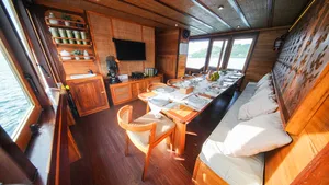 Dining table set on a wooden phinisi lounge for onboard meals during the 3D2N Komodo cruise in Labuan Bajo