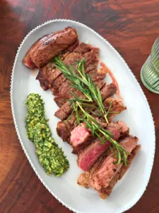 Ina Atelier craft plate with sliced beef and rosemary, on an antique European-style serving platter during workshops in Singapore