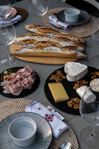 Sliced French baguettes on a wooden board with cheese, ham and nuts on a Singapore loft table for private dining Singapore