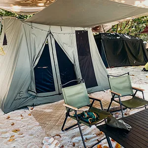 Beach camping setup on Surin Island: dome tent, folding chairs and a small table under a shaded canopy by the sand
