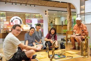 Up Travel Vietnam host-led tour in Hanoi where travellers examine carved agarwood pieces in a traditional workshop