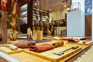 Agarwood workshop table in Hanoi with cut wood pieces and wrapped samples laid out inside an exhibition room