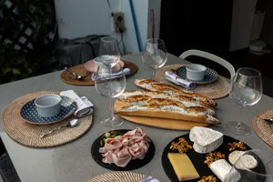 Loft dining table set with French baguettes, cheese and cured meats beside wine glasses in Singapore for private dining Singapore